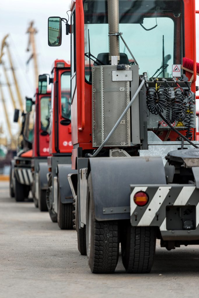 a line of red and white trucks parked in a parking lot